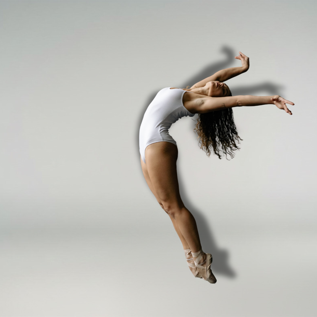 Balletttänzerin in einem weißen Trikot, die anmutig vor einem schlichten, hellen Hintergrund hüpft.