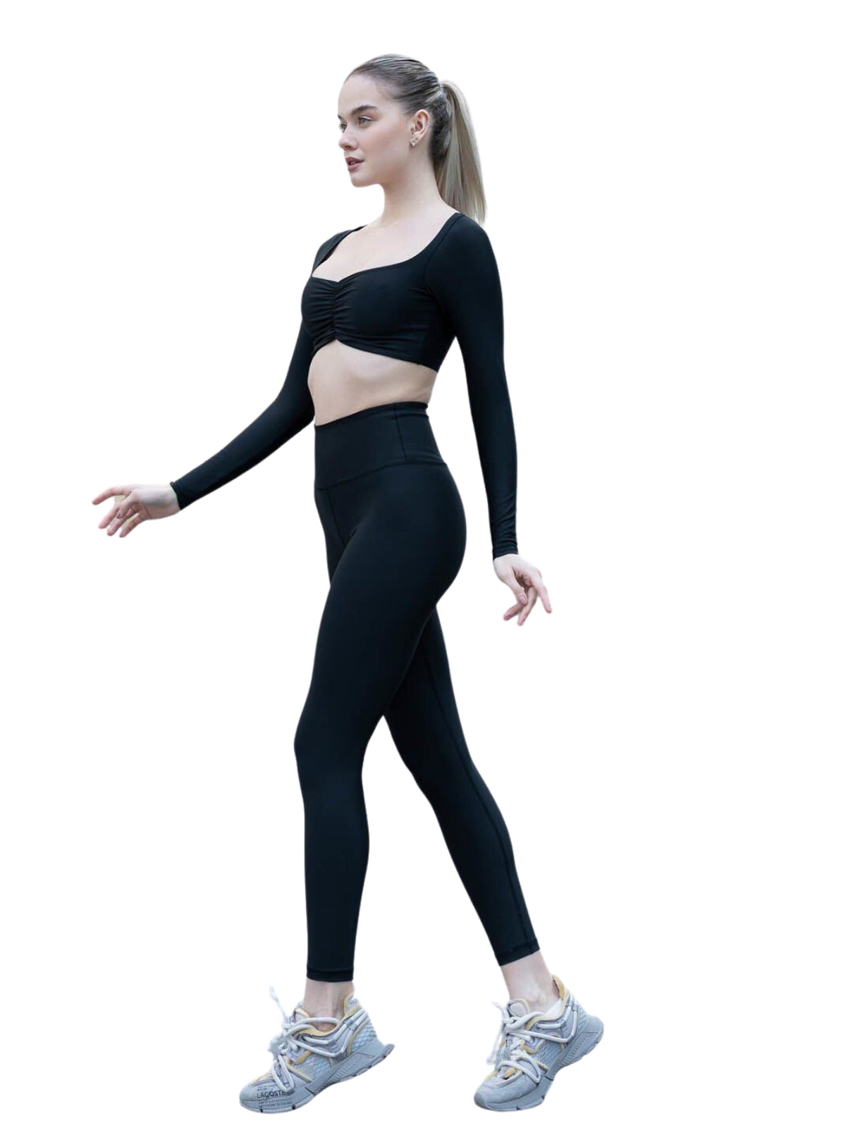 Eine Person in einem 080 Ruffled Langarm Shirt von Lismina und Turnschuhen geht selbstbewusst vor einem weißen Hintergrund.