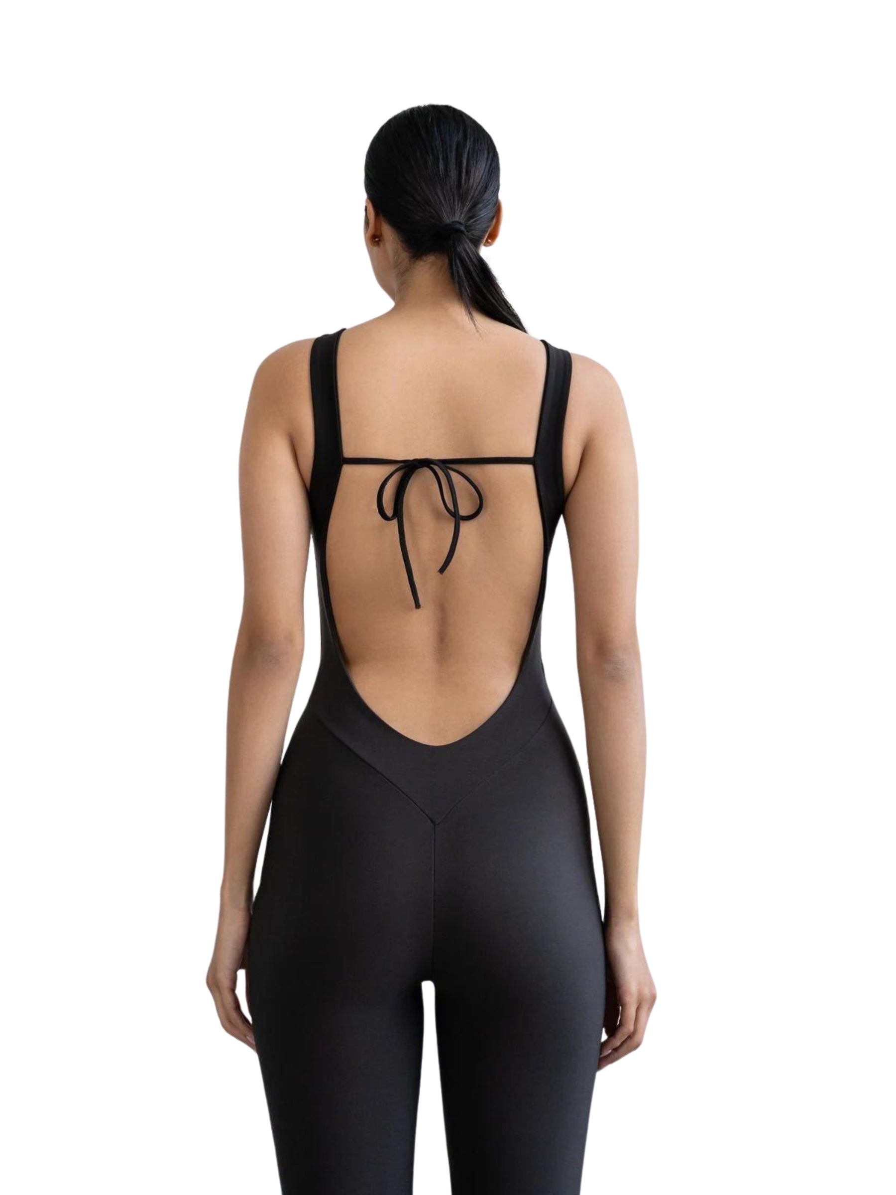Frau trägt einen Lismina 1600 schwarzen rückenfreien Jumpsuit mit gebundenen Trägern und blickt abgewandt.