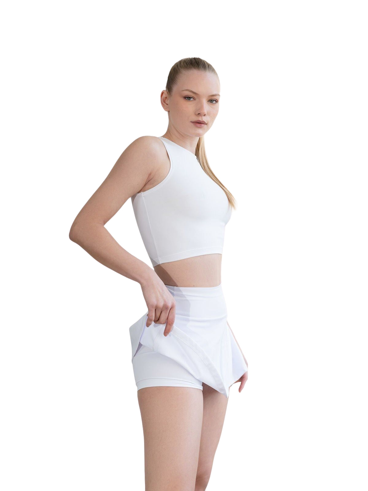 Frau hebt den 441 Rock in Weiss von Lismina, um integrierte Shorts vor weissem Hintergrund zu zeigen.