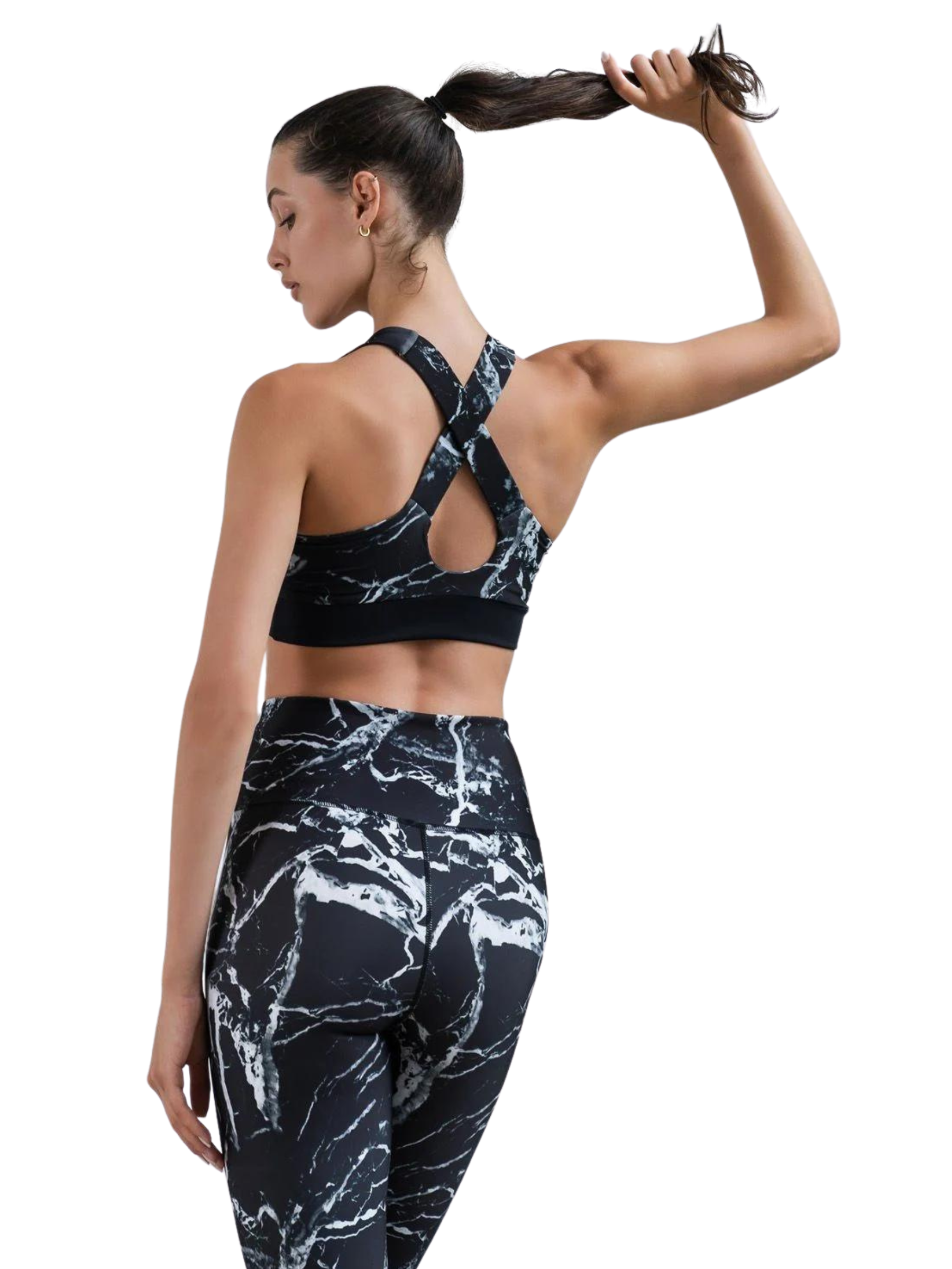 Person in 976 Capri-Leggings von Lismina mit schwarz-weißem Marmormuster posiert mit Pferdeschwanz auf weißem Hintergrund.