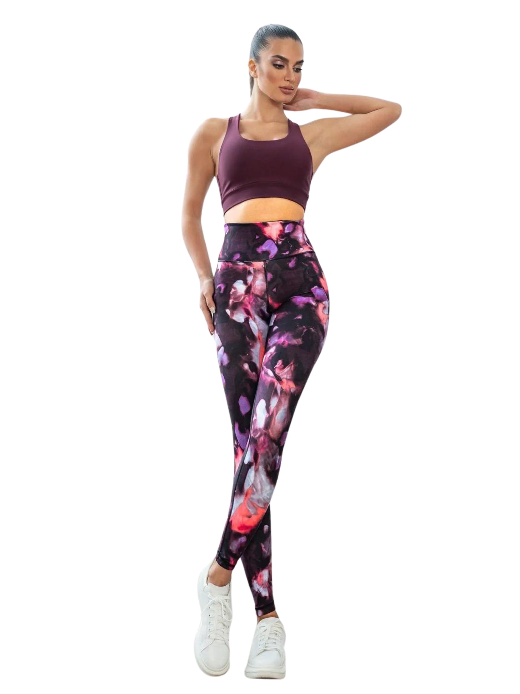 Eine selbstbewusste Pose in Lisminas 413 High Waist Leggings in Rosa-Schwarz, kastanienbraunem Sport-BH und weißen Sneakers.