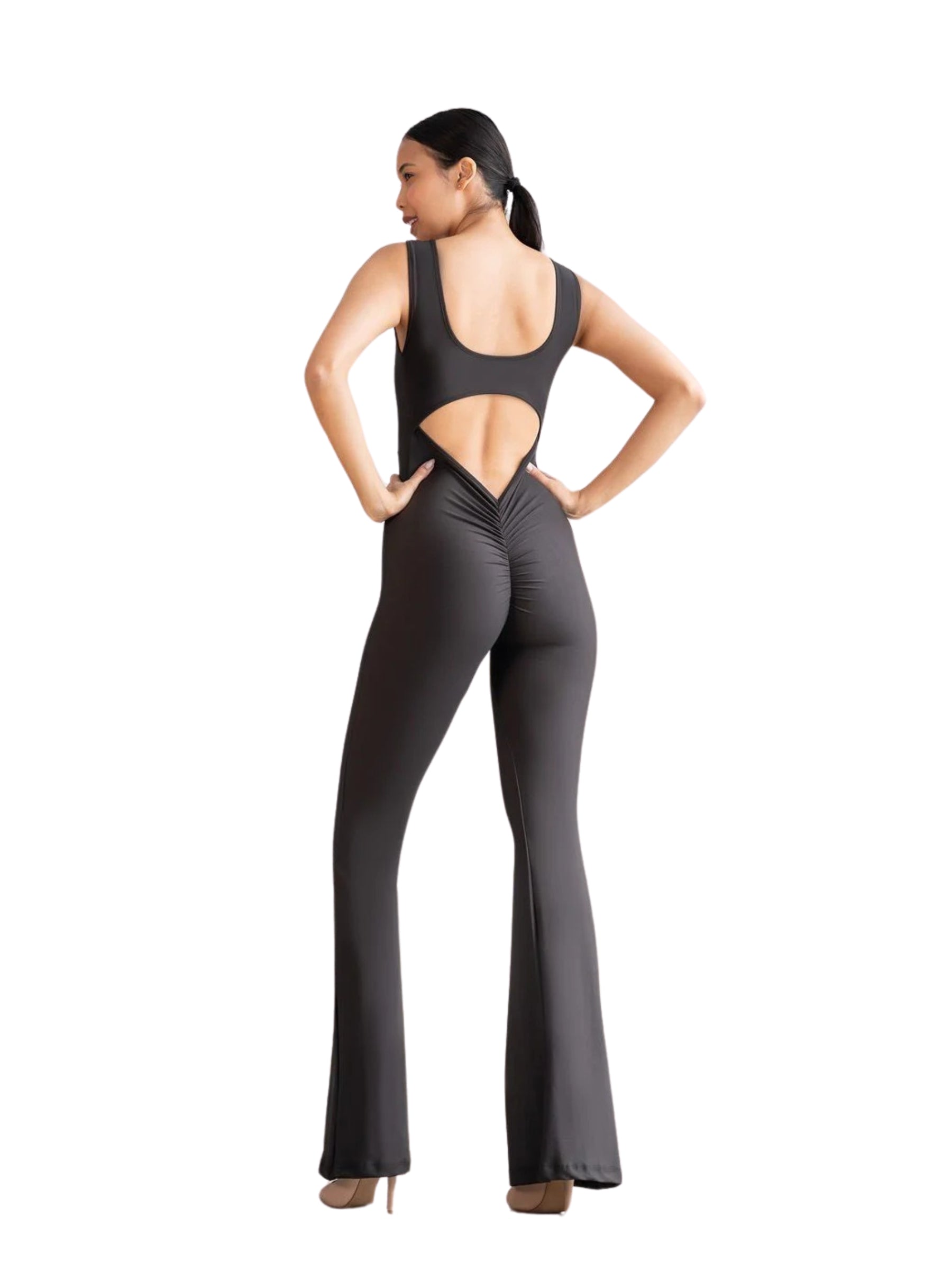 Model in einem Lismina 1500 Spanish Scrunch Butt Jumpsuit, Schwarz, mit ausgestellten Beinen auf weißem Hintergrund.