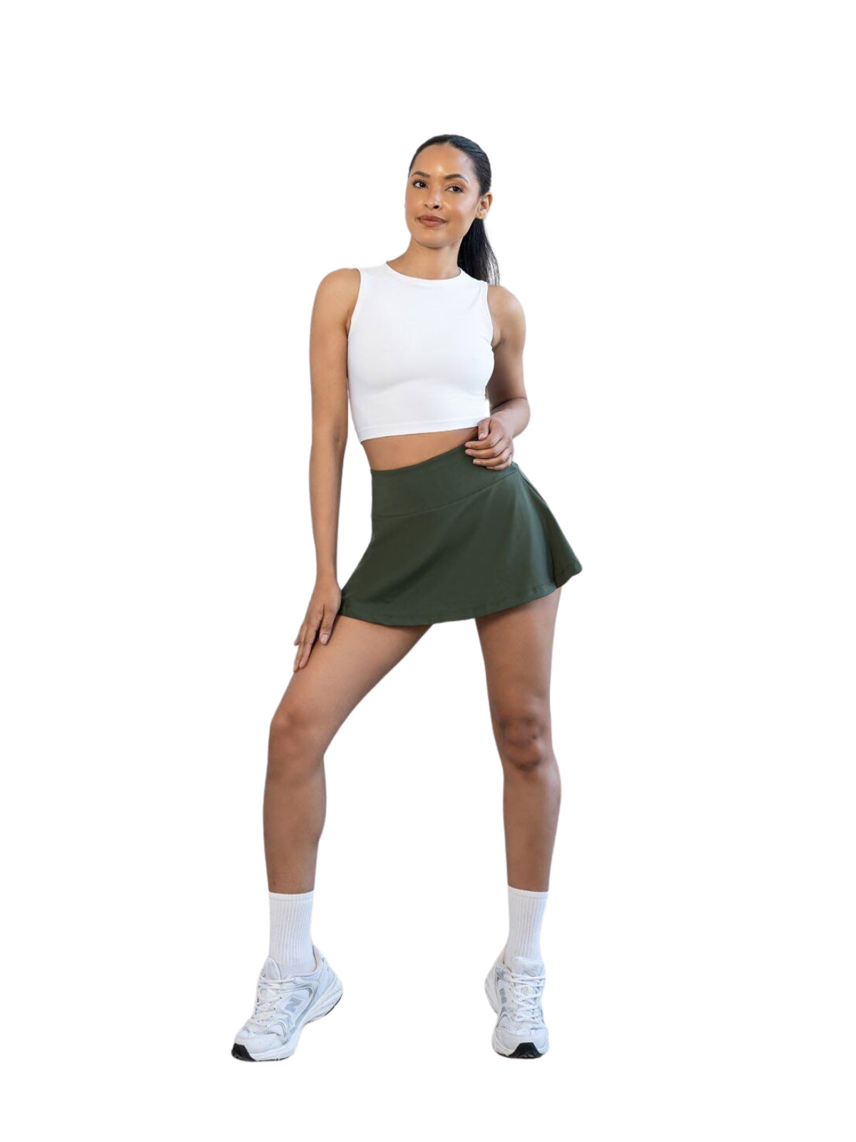 Frau in weißem Crop Top und Lismina 485 Rock in Khaki, die selbstbewusst vor einem weißen Hintergrund posiert.
