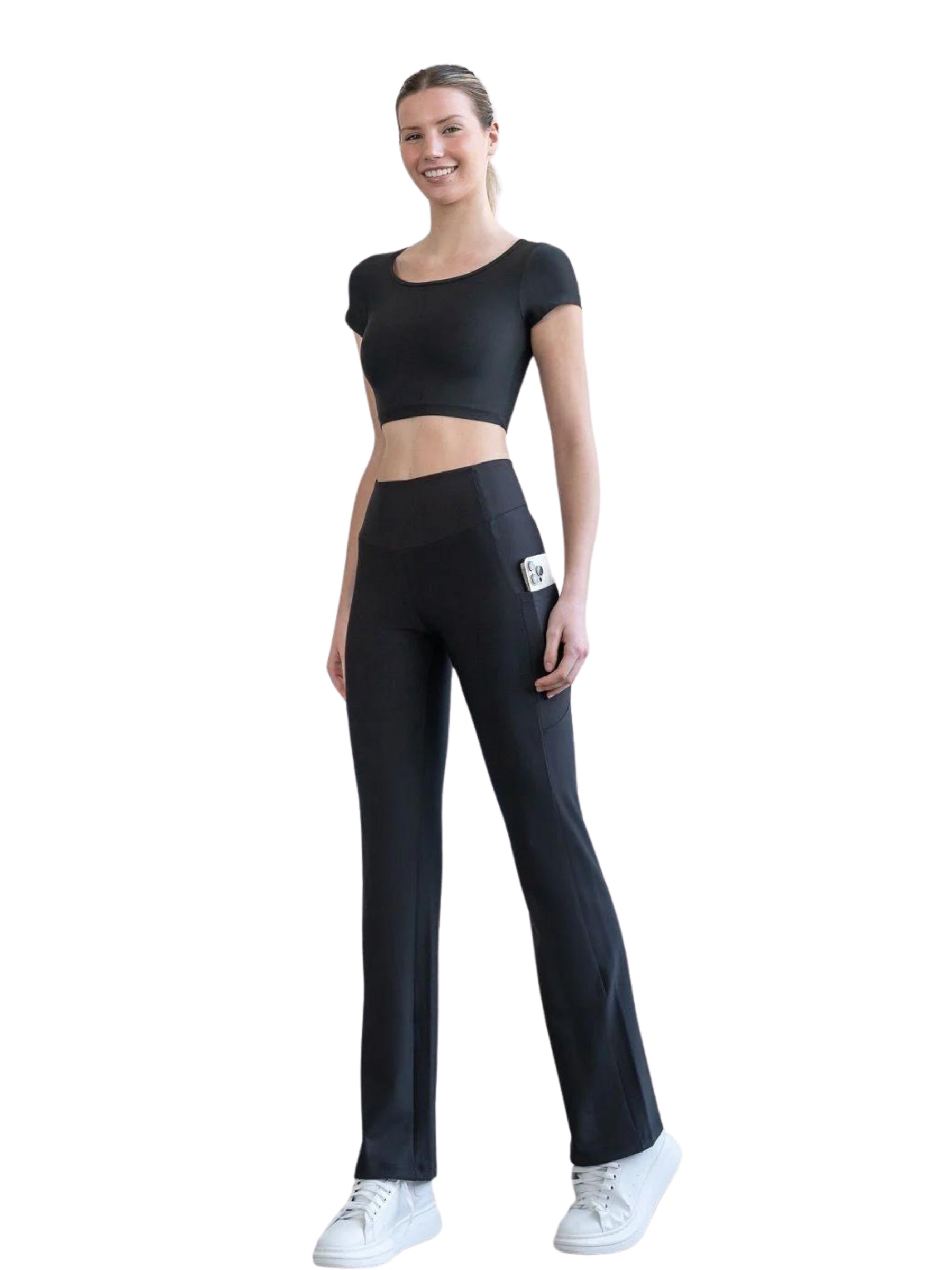 Lismina-Modell in 432 Pocket Schlagleggings, hochgeschnittenem Bund und weißen Turnschuhen vor weißem Hintergrund.