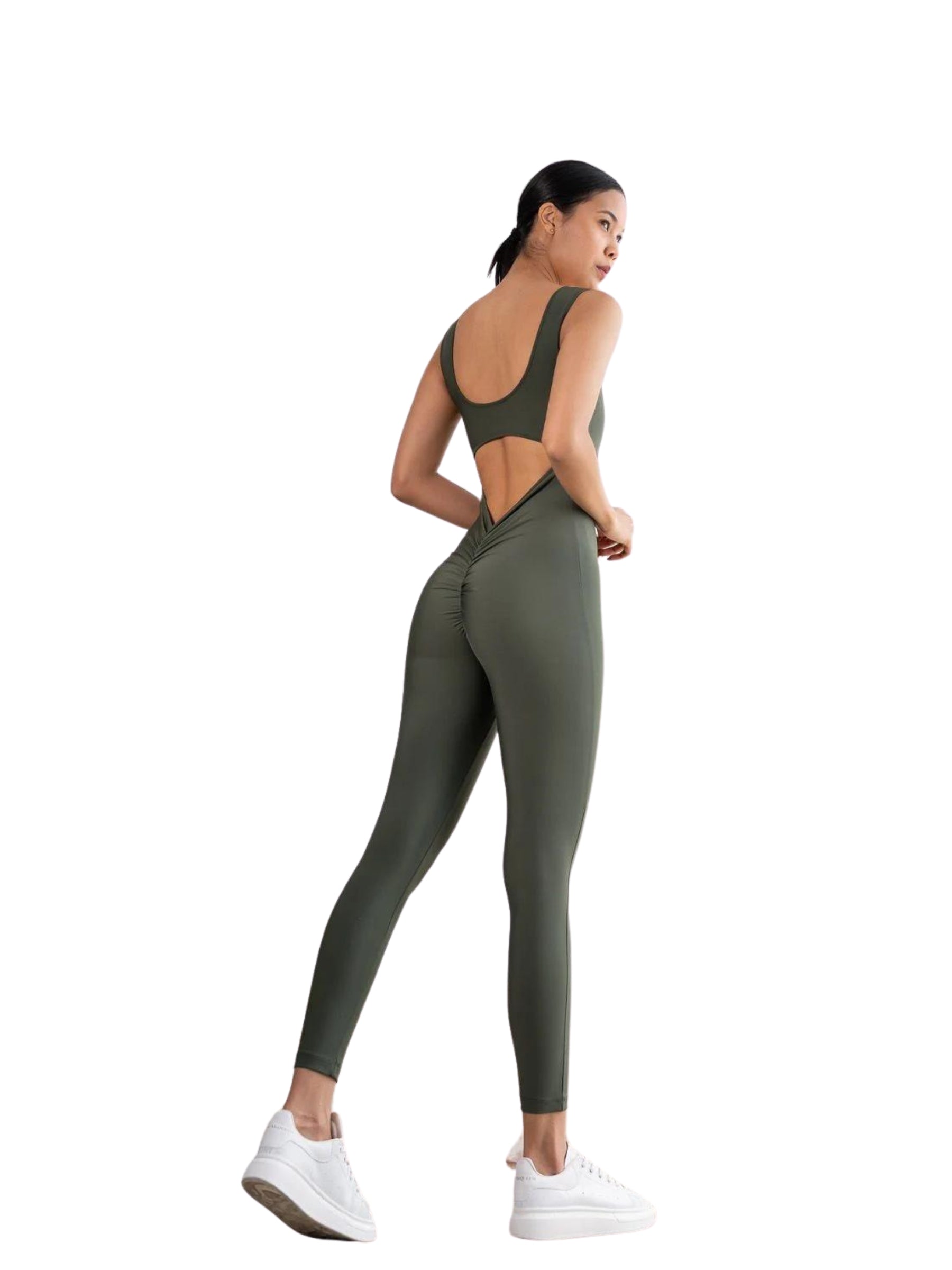 Jemand in einem Lismina 1402 Scrunch Butt Jumpsuit, Khaki, mit seitlichen Ausschnitten, im Profil mit weißen Turnschuhen.