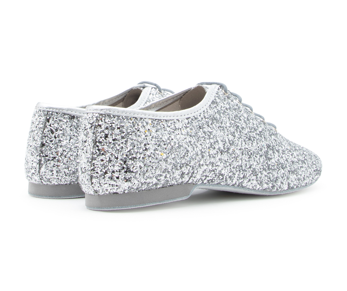 Flow Tanzschuhe in Silber Glitter von Dancing Queens mit flexibler Wildledersohle auf weißem Hintergrund.