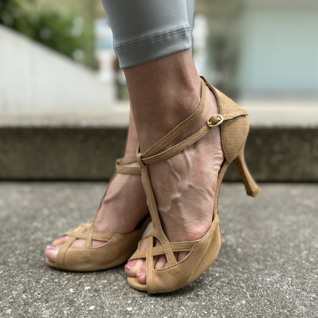 Nahaufnahme einer Person, die Portdance PD505 PREMIUM-Tanzschuhe aus Kamel-Nubukleder auf einer Betonoberfläche trägt.