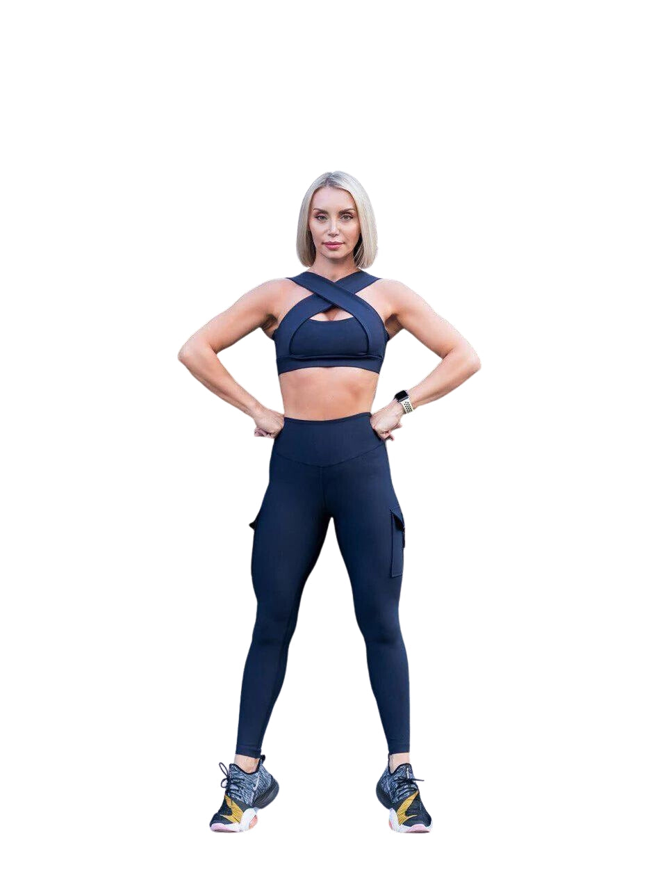 Person im Fitness-Outfit posiert selbstbewusst und trägt die 1141 Leggings mit Taschen von Lismina in Marineblau.