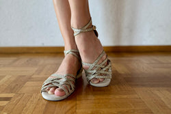 Nahaufnahme einer Person, die Dancing Queens DQ02 flache Tanzschuhe in Gold Glitter auf einem Holzboden trägt.