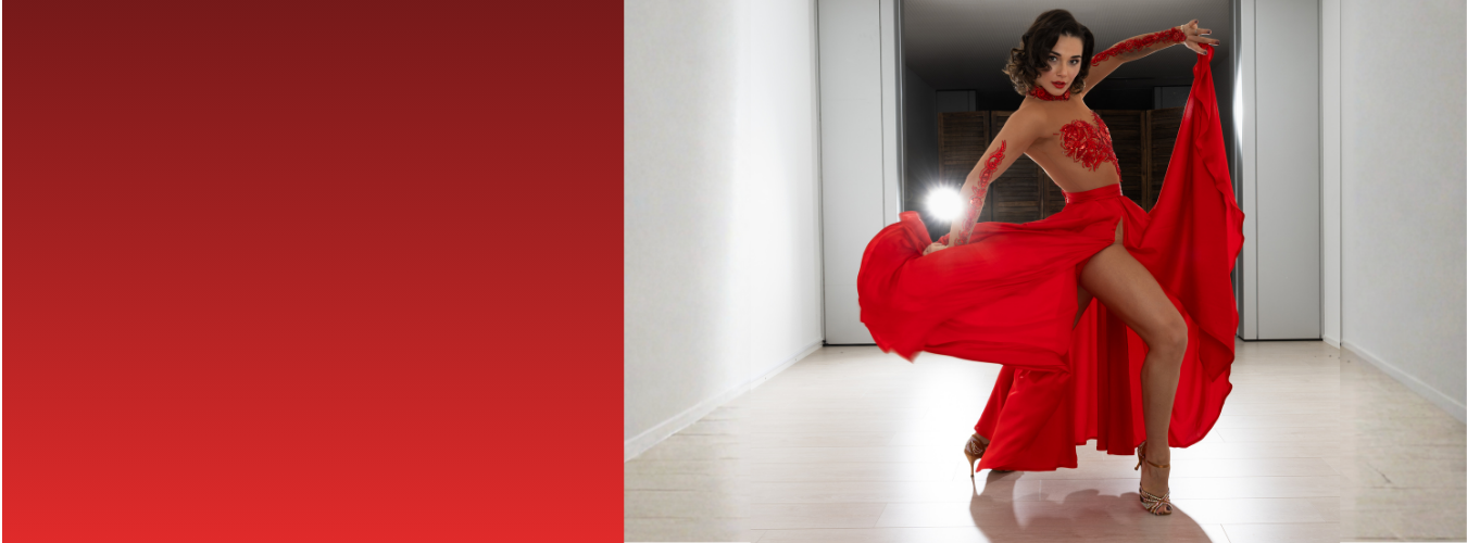 Frau in einem leuchtend roten Outfit, die in einem hell beleuchteten Flur eine dramatische Tanzpose einnimmt.