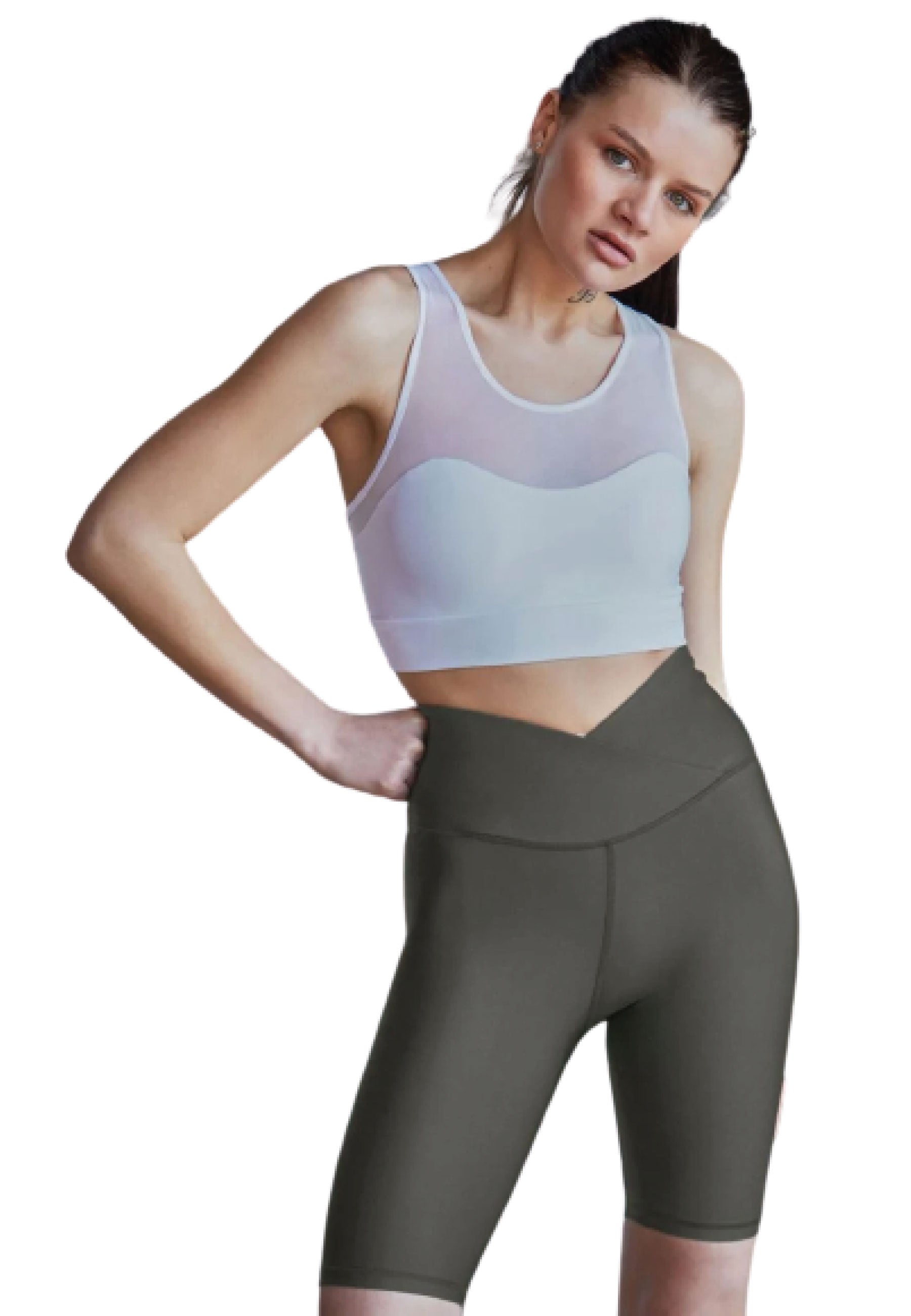 Person in Trainingskleidung, in einem Lismina 203 Sport-BH mit Tülldetails in Weiss und dunklen Shorts, posiert mit den Händen in den Hüften.