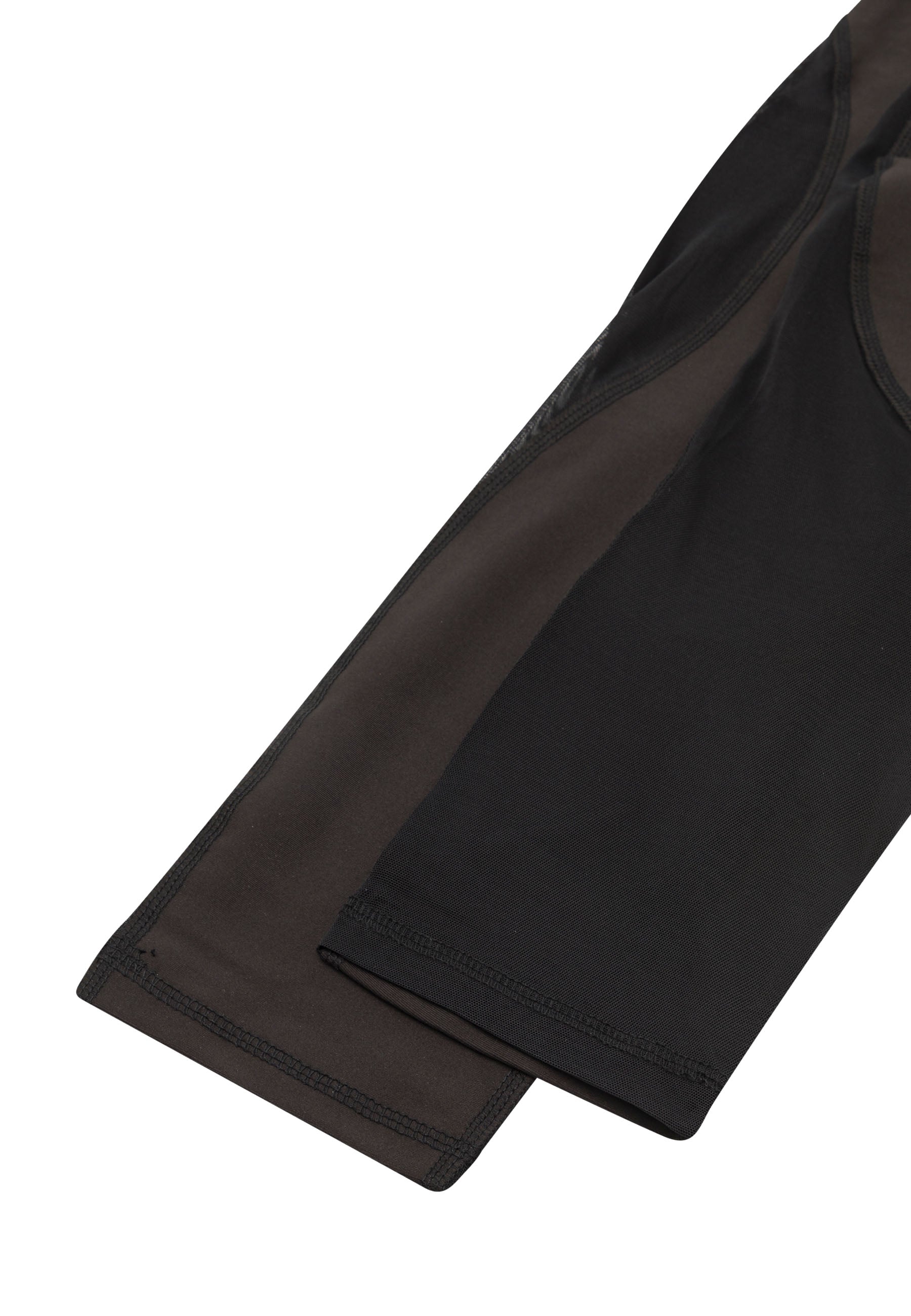 Nahaufnahme der Capri-Leggings 939 von Lismina in Schwarz mit genähten Nahtdetails und einem dunkelgrünen Langarmoberteil.