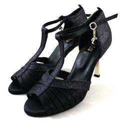 Norma Tanzschuhe NS01-G01 von Dancing Queens: schwarze Riemchen-High-Heels mit goldenen Anhängern, perfekt zum Tanzen.