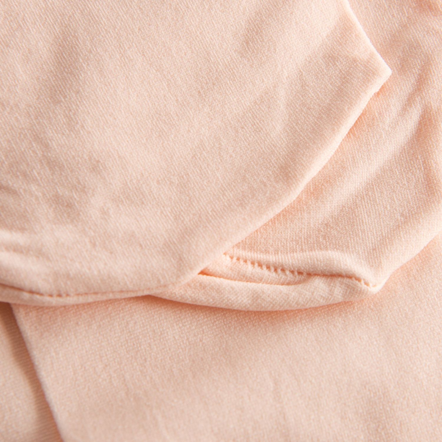 Nahaufnahme der gefalteten 108 Economy Ballettstrumpfhose in zartem Rosa von Rumpf, die Nähte und glatte Textur hervorhebt.