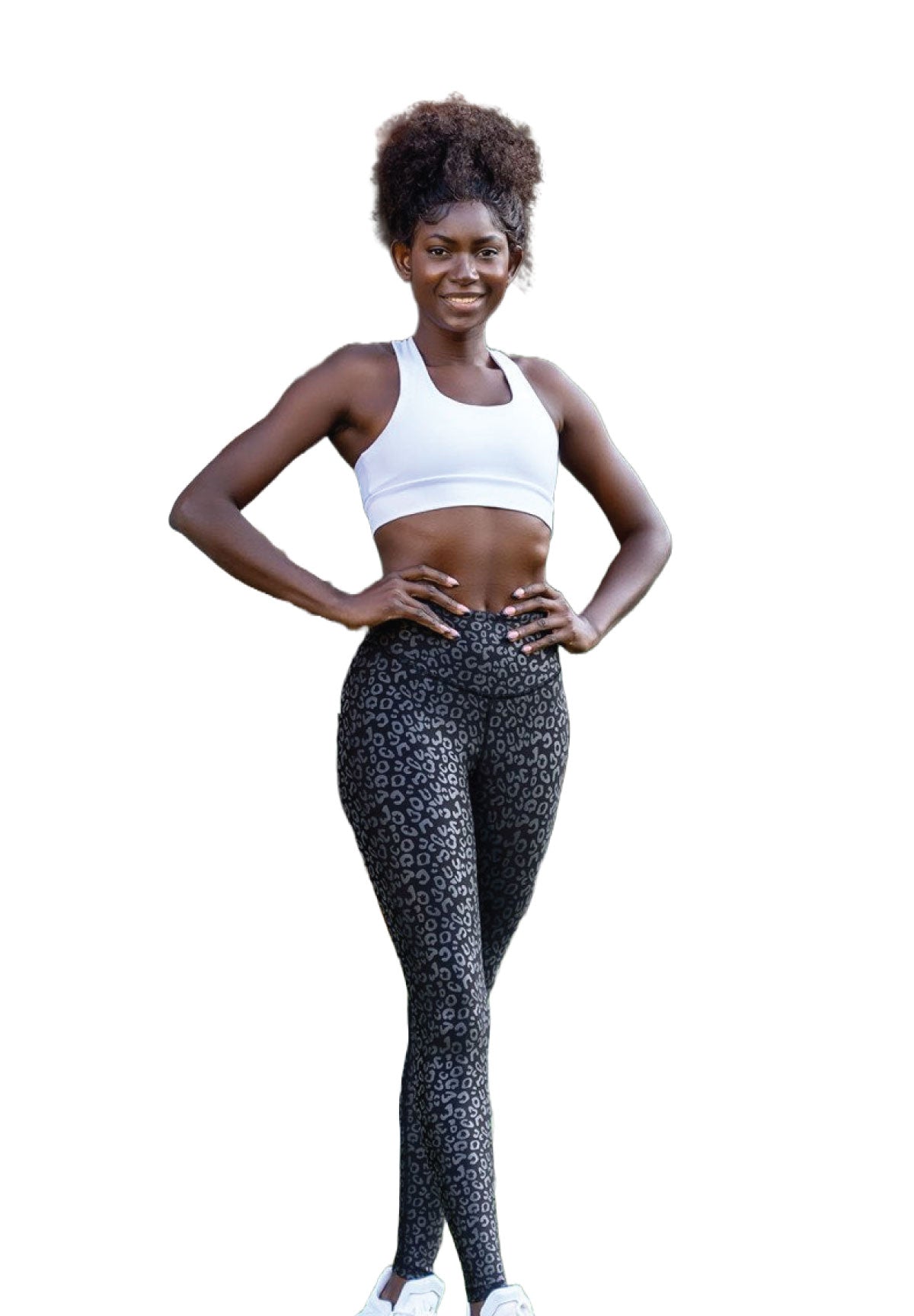 Lächelnde Frau in Lismina 1150 Schwarz & Silber Leder-Look-Leggings und weißem Sport-BH, Hände in die Hüften gestemmt.