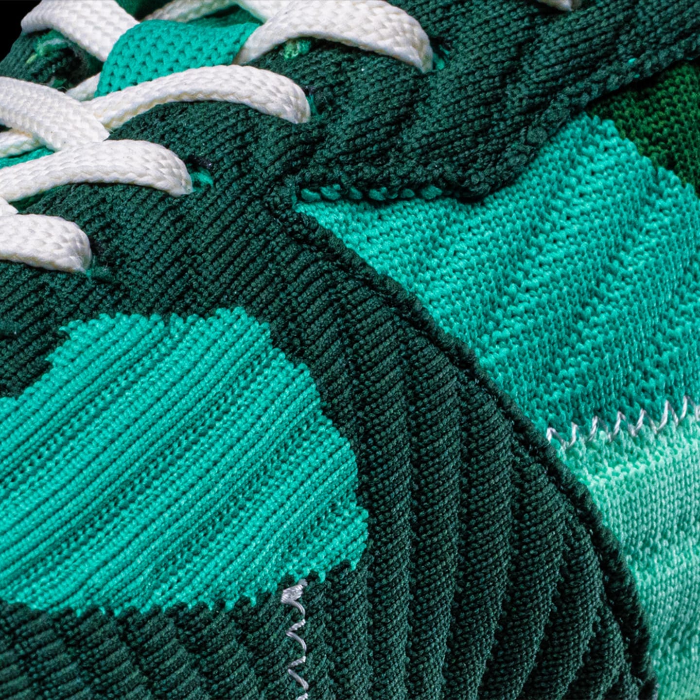 Nahaufnahme der grünen Fuego Jade-Sneaker von Fuego Dance Shoes mit weißen Schnürsenkeln und gesteppter Textur aus recyceltem Kunststoff.